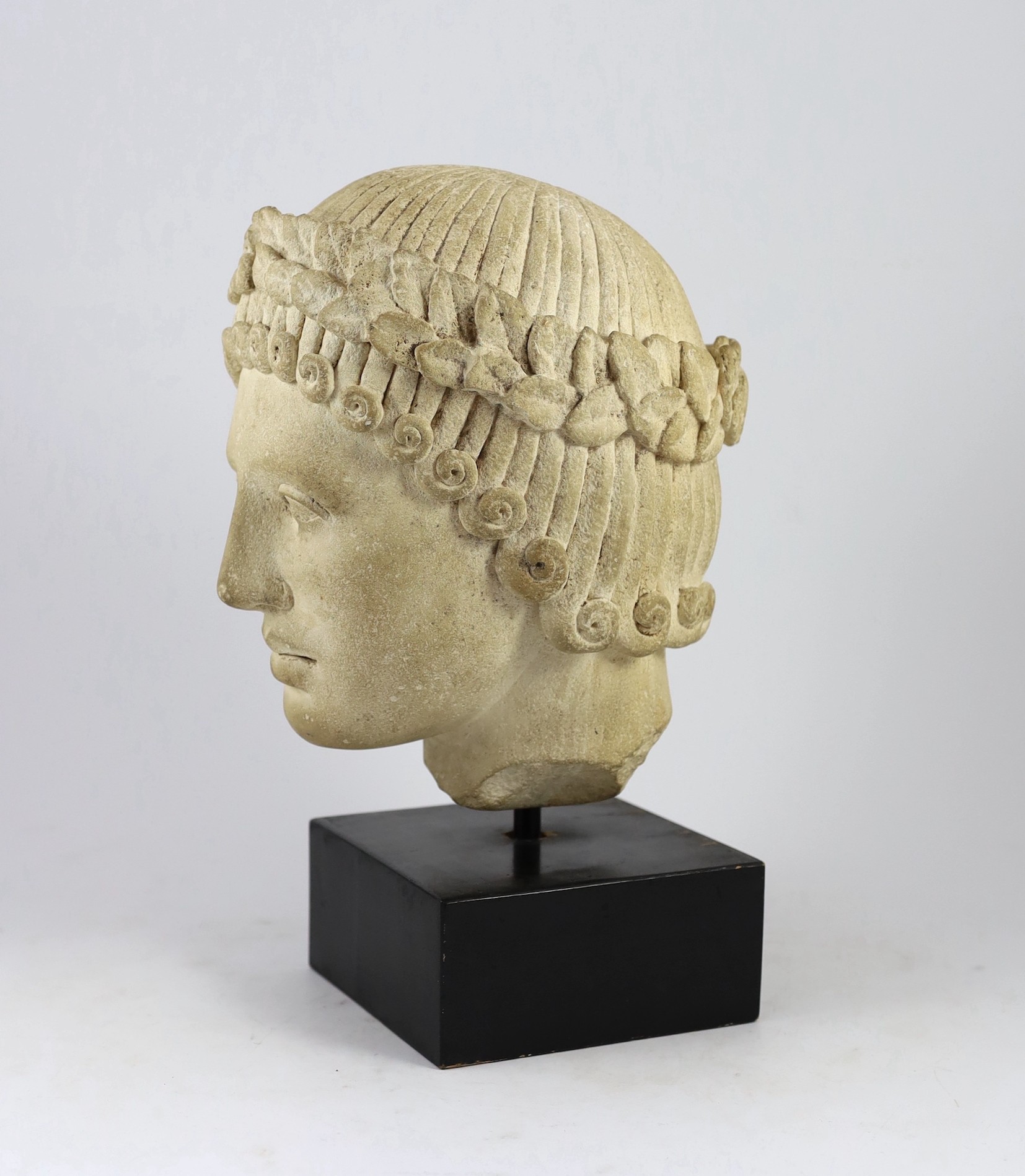 An antique limestone head wearing a laurel wreath diadem, possibly 18th/19th century, 29cm high overall 39cm
